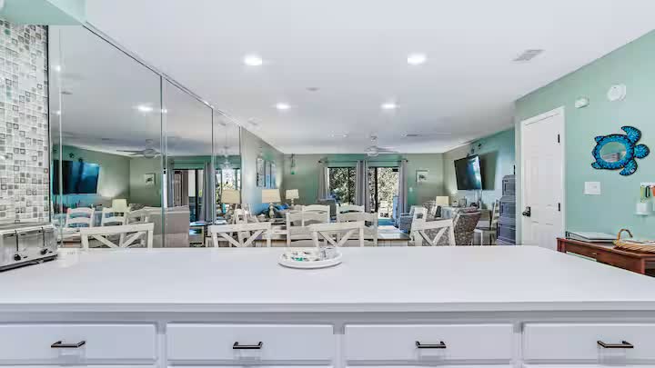 Kitchen island looking across the dining area and mirrored wall to the living room